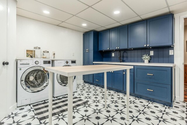 washroom featuring recessed lighting, washing machine and dryer, cabinet space, and light floors