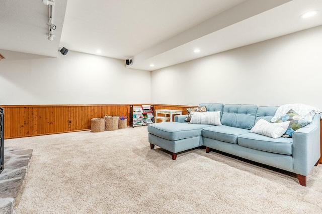 carpeted living area with recessed lighting, wooden walls, track lighting, and wainscoting