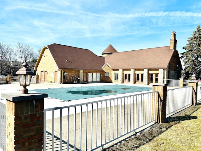 community pool featuring a patio area, fence, and french doors