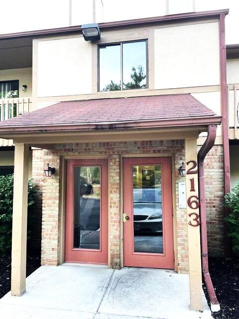 property entrance with brick siding and stucco siding