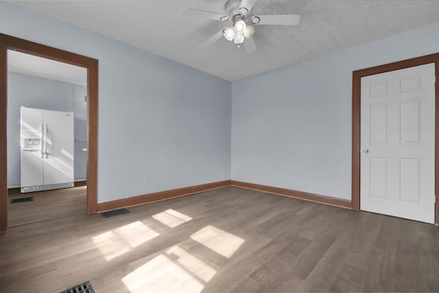 879 Mansfield Ave, Columbus, OH 43219 - empty room with a textured ceiling, wood finished floors, a ceiling fan, and baseboards