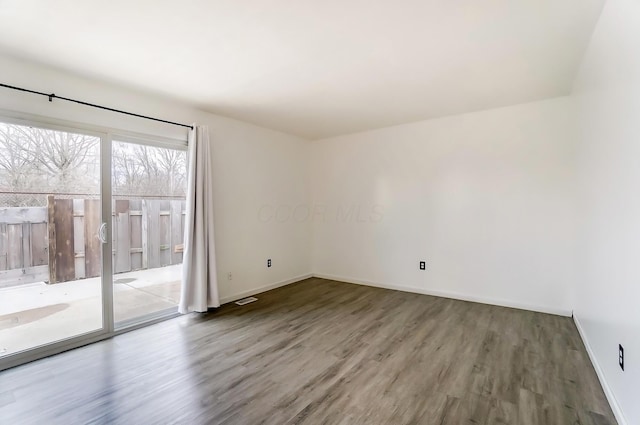 empty room with baseboards and wood finished floors