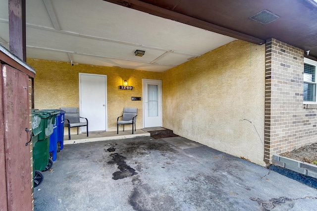 view of exterior entry featuring a patio area and stucco siding