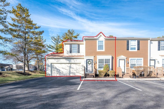 view of property with a garage and uncovered parking