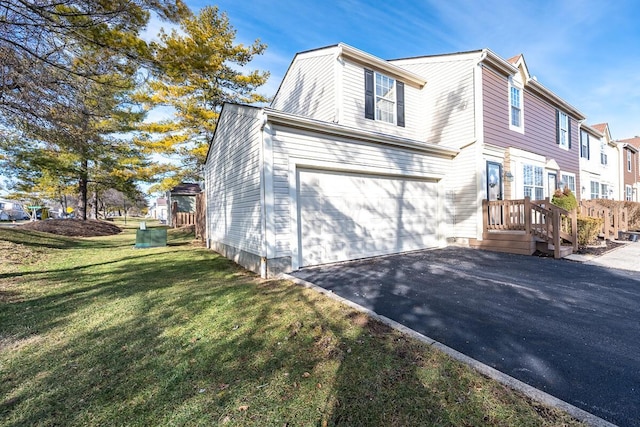 view of side of property featuring aphalt driveway and a yard