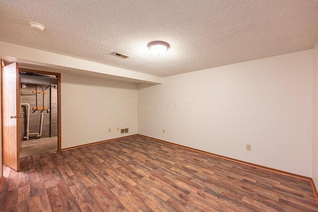 finished basement with visible vents, baseboards, and wood finished floors