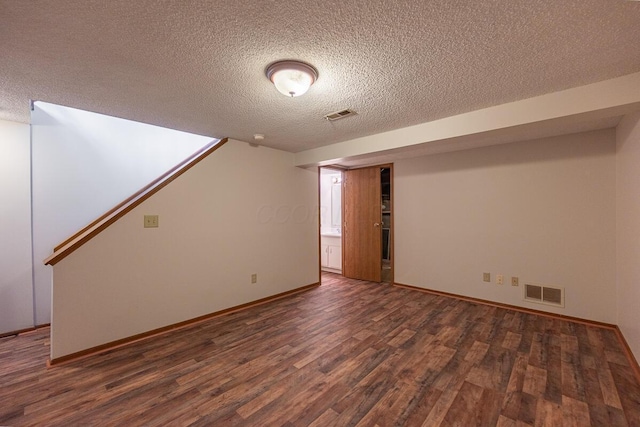 basement featuring baseboards, a textured ceiling, visible vents, and wood finished floors