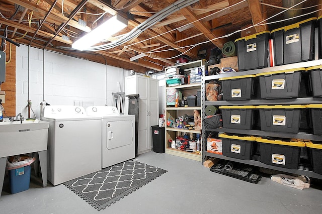 clothes washing area featuring laundry area, independent washer and dryer, concrete block wall, and electric panel