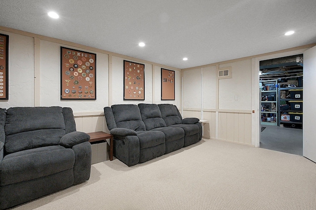 carpeted living room with recessed lighting, visible vents, and a decorative wall