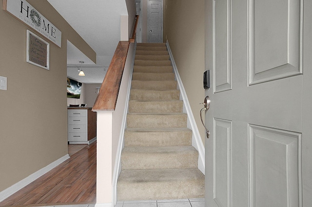 stairs with baseboards and wood finished floors