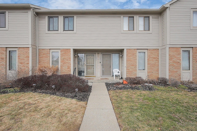 view of front of house featuring a front yard and brick siding