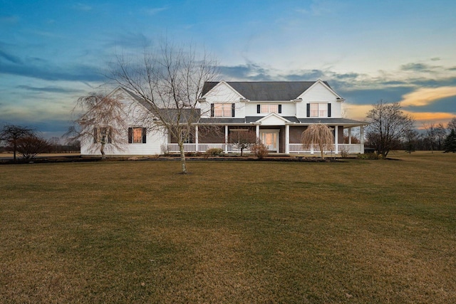 view of front of home with a porch and a lawn