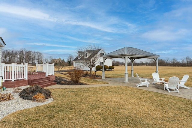 view of yard with a fire pit, a gazebo, a patio area, and a wooden deck