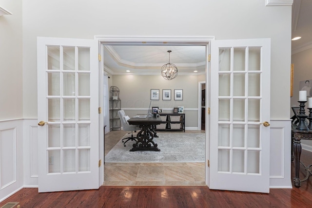 interior space with wood finished floors, an inviting chandelier, a tray ceiling, crown molding, and recessed lighting