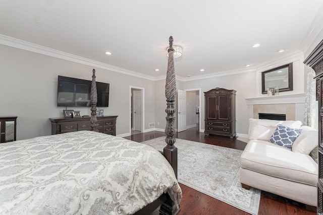 bedroom featuring baseboards, dark wood-type flooring, a tiled fireplace, and crown molding