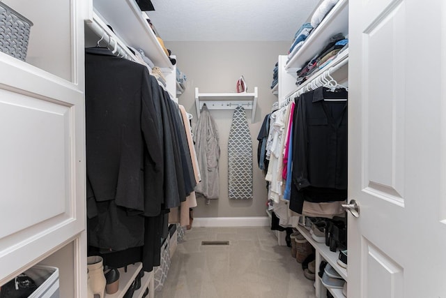 walk in closet with light colored carpet and visible vents