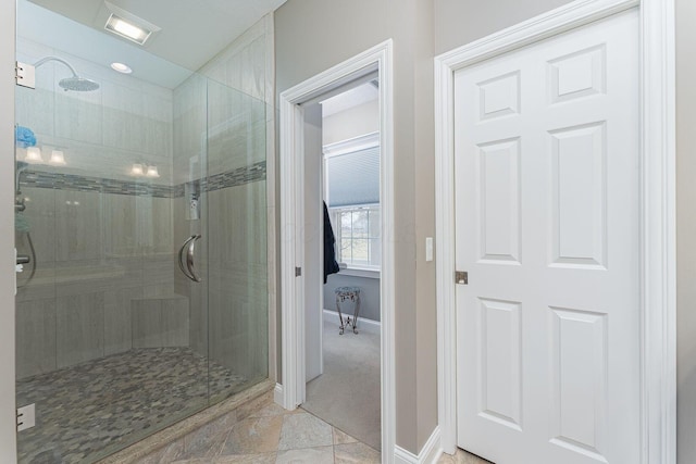 bathroom featuring a shower stall and baseboards