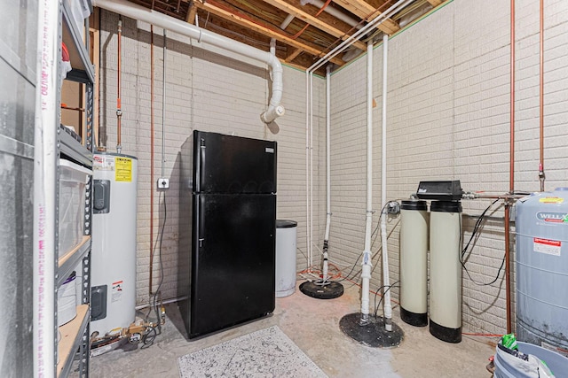 below grade area featuring water heater and freestanding refrigerator