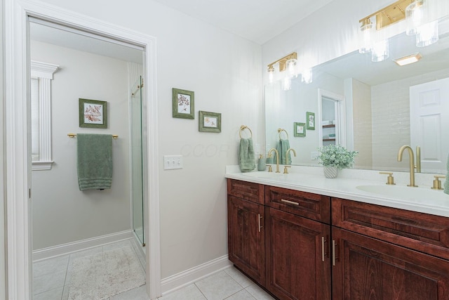 bathroom featuring a shower stall, double vanity, a sink, and tile patterned floors