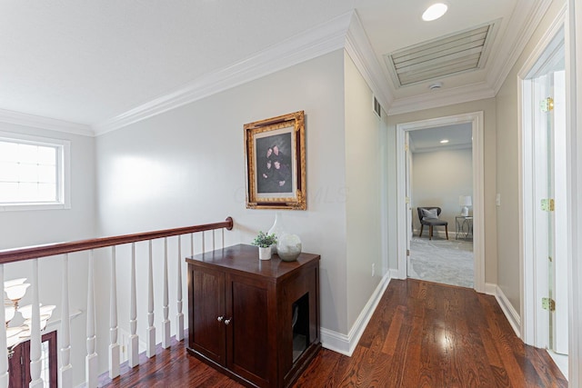 hall featuring dark wood-style flooring, visible vents, crown molding, and baseboards