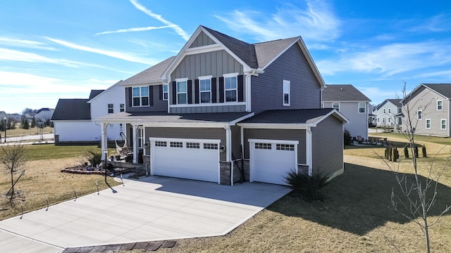 craftsman inspired home with a garage, concrete driveway, stone siding, a residential view, and board and batten siding