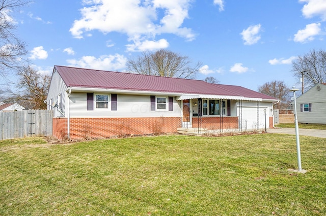 ranch-style house with metal roof, an attached garage, brick siding, fence, and a front yard