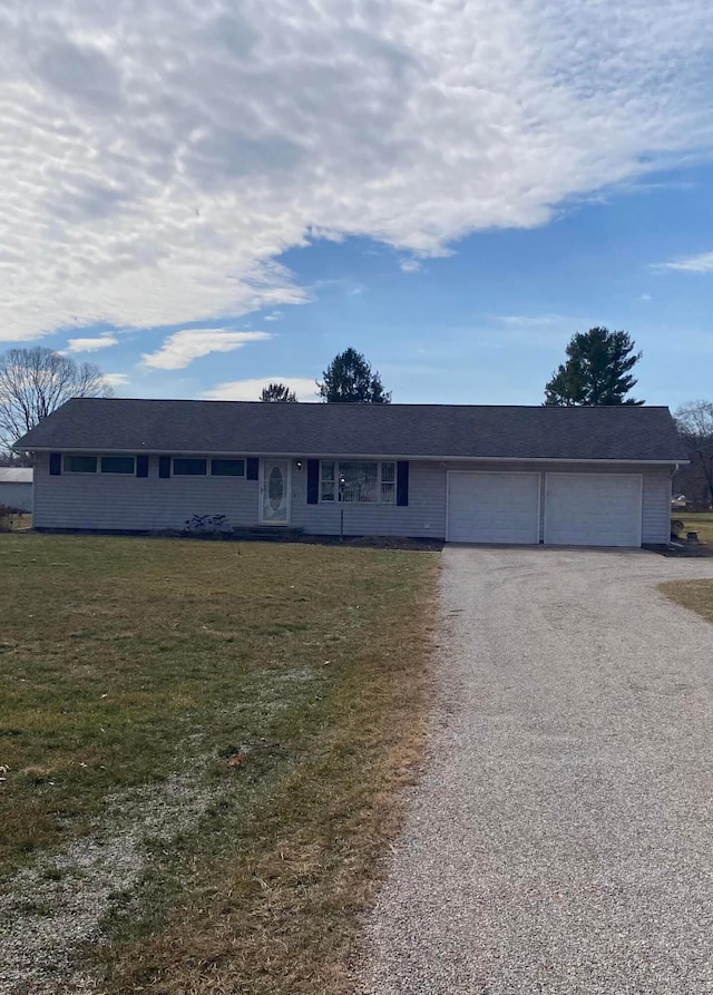 single story home with an attached garage, driveway, and a front yard