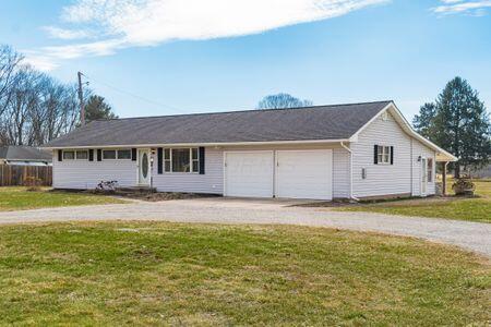 ranch-style house featuring a garage, driveway, and a front yard