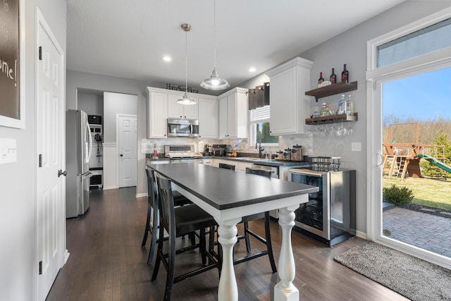 kitchen with dark countertops, wine cooler, stainless steel appliances, and dark wood-style flooring