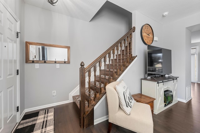 foyer with stairs, wood finished floors, visible vents, and baseboards