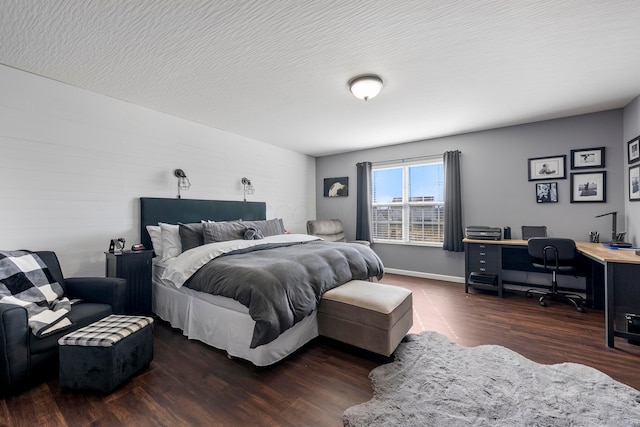 bedroom with a textured ceiling, wood finished floors, and baseboards