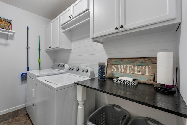 washroom featuring stone finish floor, cabinet space, baseboards, and separate washer and dryer