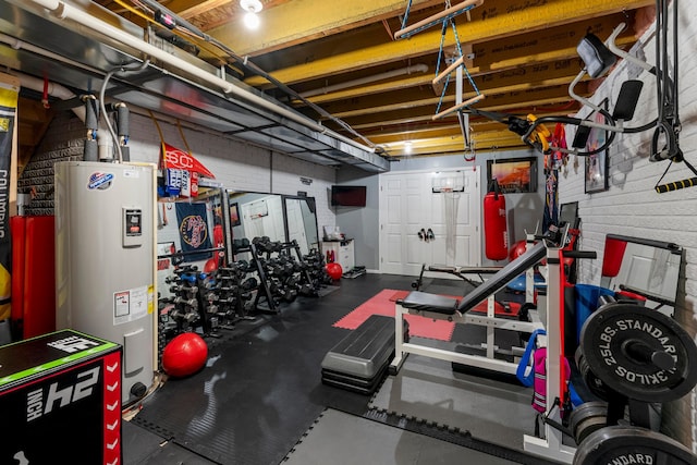 workout area featuring brick wall and electric water heater