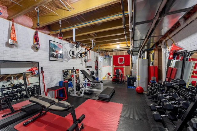 workout area with water heater and brick wall