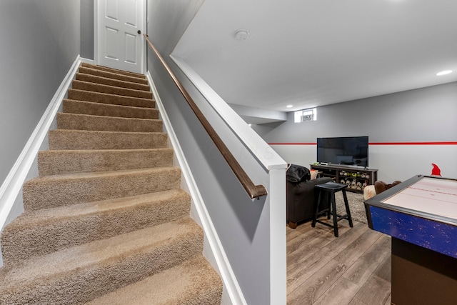 staircase with wood finished floors and recessed lighting