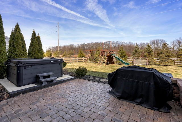 view of patio with a hot tub, fence, a grill, and a playground