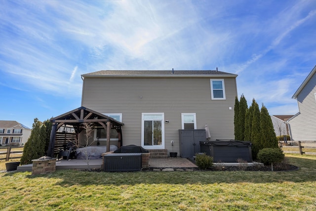 rear view of house featuring a gazebo, a yard, a patio area, and a hot tub