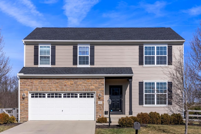 traditional-style home with roof with shingles, concrete driveway, an attached garage, fence, and stone siding