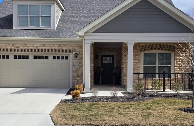 view of front of home featuring covered porch, driveway, a shingled roof, and stone siding