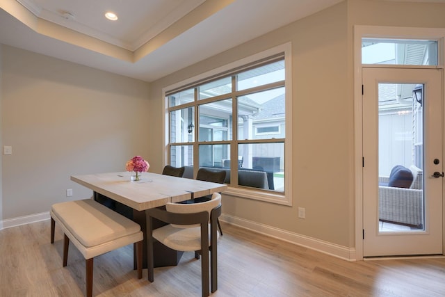 dining space featuring light wood-type flooring, baseboards, a tray ceiling, and recessed lighting