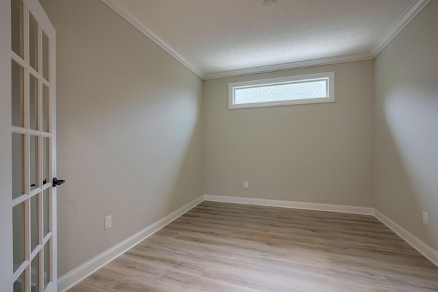 unfurnished room with light wood-style flooring, ornamental molding, and baseboards