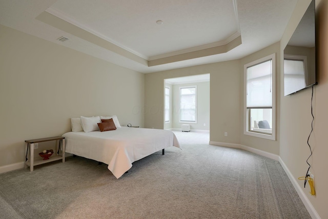 bedroom with light carpet, visible vents, baseboards, a raised ceiling, and crown molding