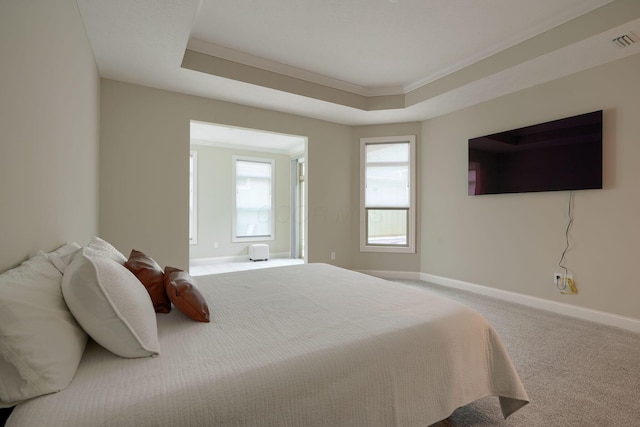 bedroom featuring baseboards, visible vents, ornamental molding, a tray ceiling, and carpet flooring