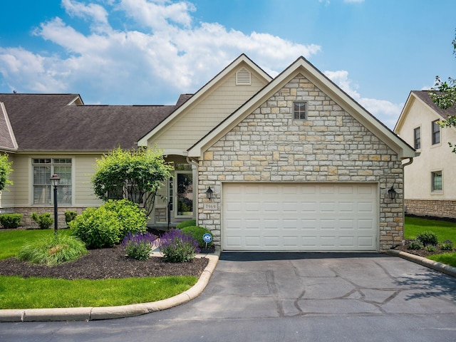 7969 Linksview Cir, Westerville, OH 43082 - view of front facade with stone siding, asphalt driveway, and an attached garage