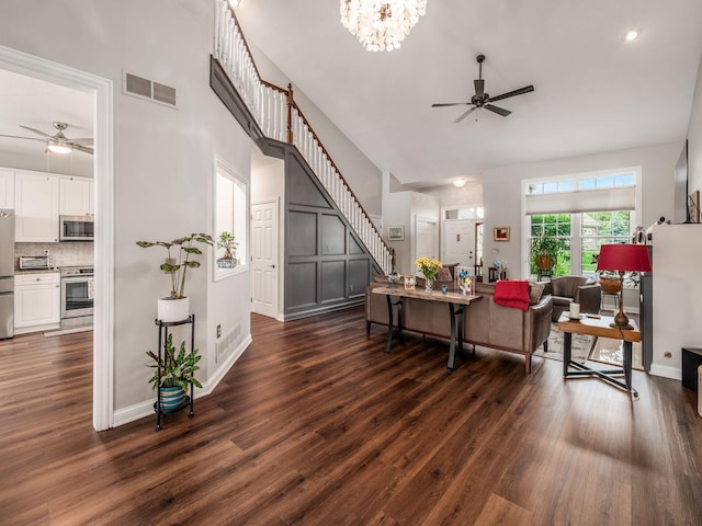 7969 Linksview Cir, Westerville, OH 43082 - living room featuring a ceiling fan, stairway, dark wood-type flooring, a high ceiling, and a chandelier