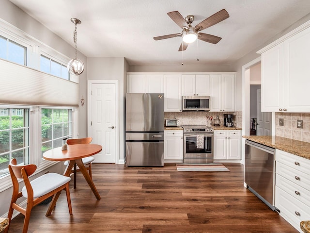 7969 Linksview Cir, Westerville, OH 43082 - kitchen featuring appliances with stainless steel finishes, dark wood-style flooring, decorative backsplash, and light stone counters