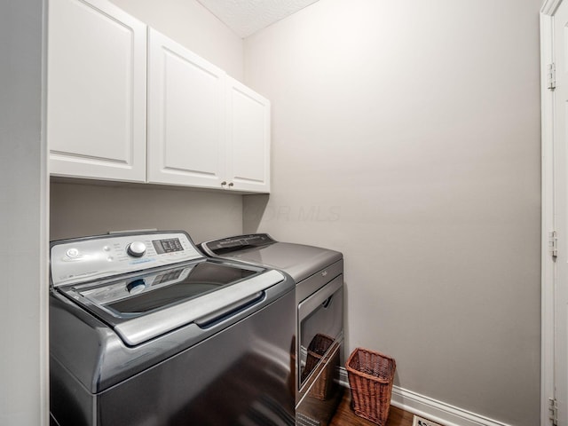7969 Linksview Cir, Westerville, OH 43082 - laundry room with washing machine and dryer, cabinet space, and wood finished floors