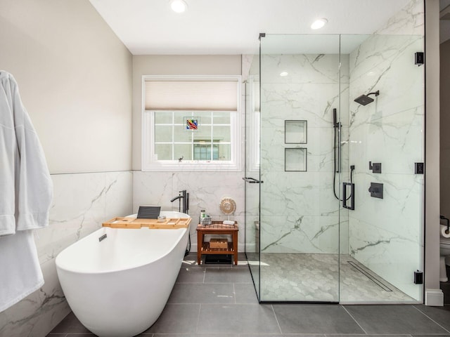 7969 Linksview Cir, Westerville, OH 43082 - bathroom featuring a freestanding tub, a marble finish shower, tile walls, recessed lighting, and tile patterned flooring