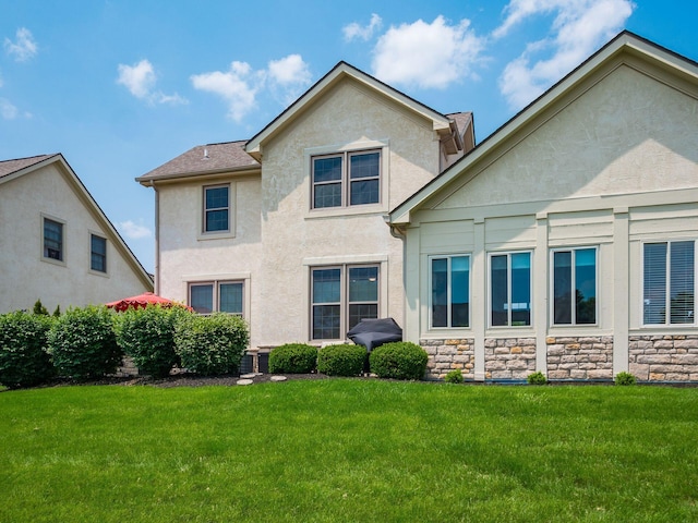 7969 Linksview Cir, Westerville, OH 43082 - back of house with stucco siding, a lawn, and stone siding