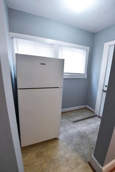 kitchen with baseboards and freestanding refrigerator